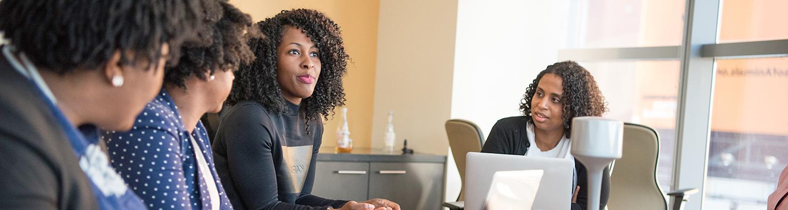 African America Women in corporate setting talking